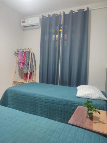 a bedroom with a bed with a blue curtain at Casa c 3 Suítes 4 banheiros 4 quartos climatizados a passos da Praia, Centro e comércios in Alcobaça