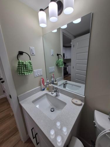 a bathroom with a sink and a mirror at Clear Edge Suites in Saskatoon