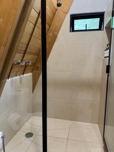 a shower with a glass door in a bathroom at Aldea KilTik in Coatitilán