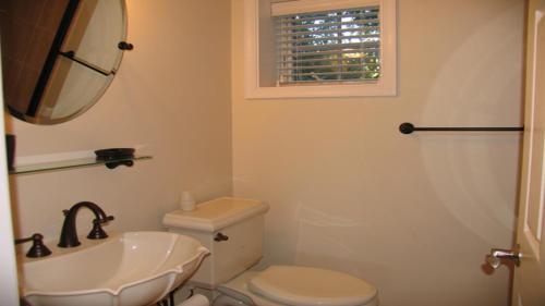 a bathroom with a sink and a toilet and a mirror at Condo At The Cove Unit 5 in Cape May