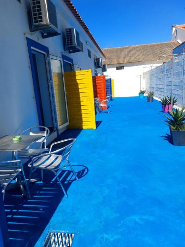a patio with chairs and a table in front of a building at vila gira odeceixe in Odeceixe