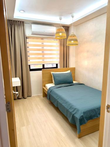 a bedroom with a bed and two pendant lights at Dasma stay - Private Jacuzzi and Skyline Views in Dasmariñas