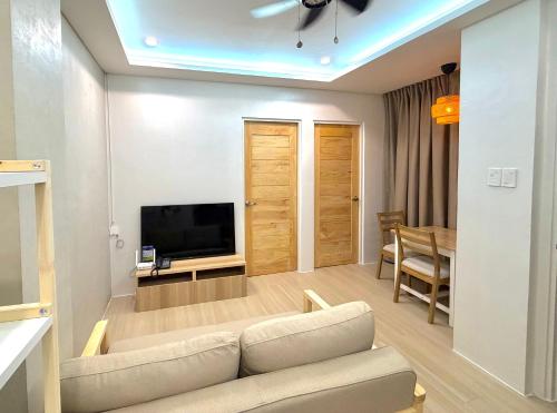 a living room with a couch and a television at Dasma stay - Private Jacuzzi and Skyline Views in Dasmariñas