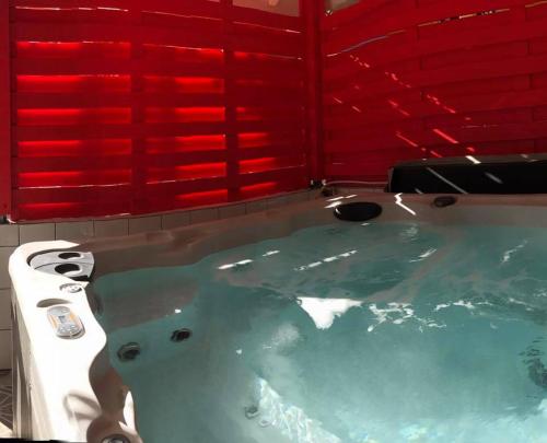 a bath tub in a bathroom with a red window at La Pointe d'Argent in Pointe-Noire