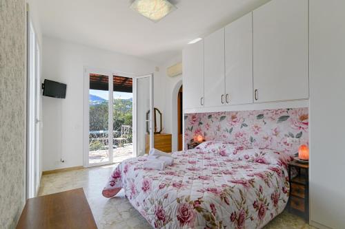 a bedroom with a large bed with a floral bedspread at Rosa di Ischia - Holiday in Ischia Town