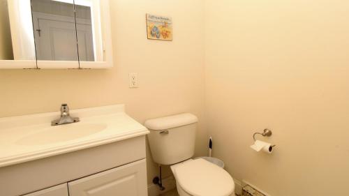 a bathroom with a toilet and a sink and a mirror at 215 Heritage Lane in Cape May