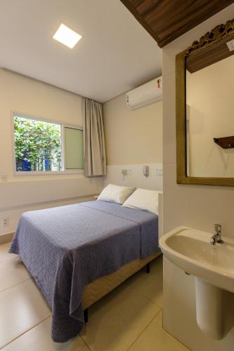 a bedroom with a bed and a sink at K2 RESIDENCE Campinas in Campinas
