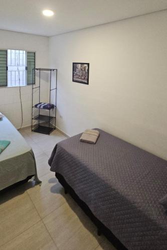 a bedroom with a bed and a shelf in it at Casa Completa e Confortável em Cotia in Cotia