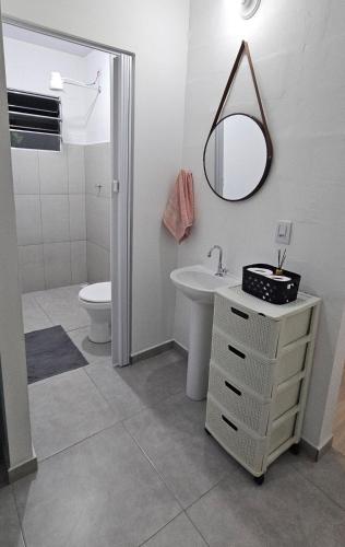 a bathroom with a sink and a toilet and a mirror at Casa Completa e Confortável em Cotia in Cotia