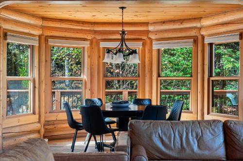 a dining room with a table and chairs and windows at Fiddler Lake Resort - Rabbit 66 in Mille-Isles