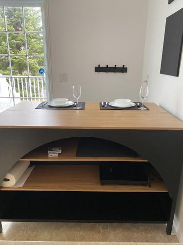 a desk with two plates and two glasses on it at LE 710 Maison d'invitée in Saint-Georges