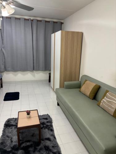 a living room with a green couch and a table at Ally home 0624 in Thung Si Kan
