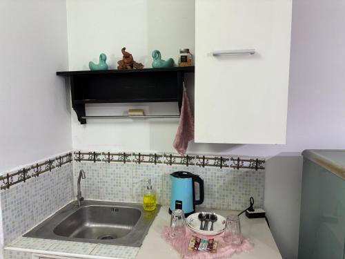 a kitchen with a sink and a counter top at Ally home 0624 in Thung Si Kan