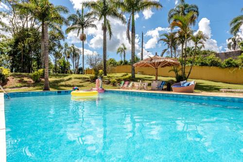 a person in a raft in a pool at a resort at Paraíso com Piscina, Churrasqueira, Wi-Fi e Karaokê in Ibiúna
