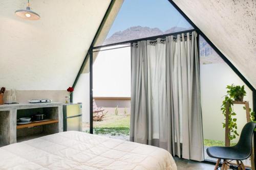 a bedroom with a bed and a large window at Portal M Chalets in Chalma
