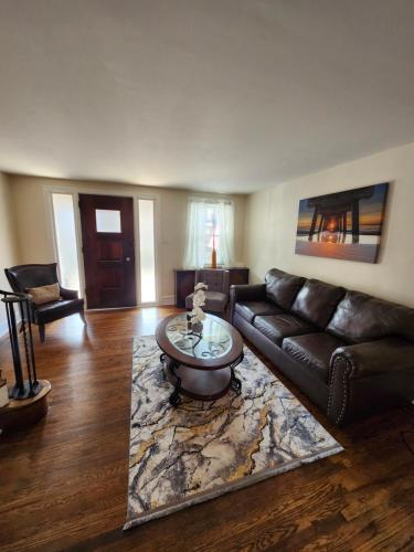 a living room with a leather couch and a coffee table at Lansdowne Gem in Lansdowne