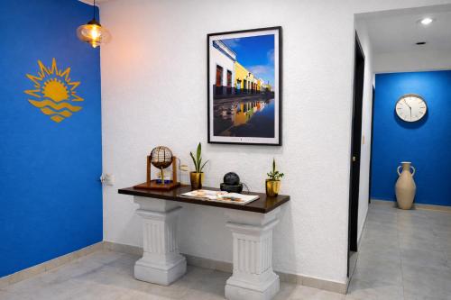 a hallway with a table and a clock on the wall at Hotel Puesta del Sol in Campeche