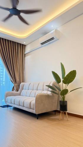 a living room with a couch and a ceiling fan at SeFA Cozy Stay in Malacca