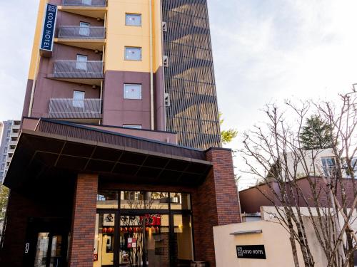 a tall building in front of a building at KOKO HOTEL Akabane Station in Tokyo