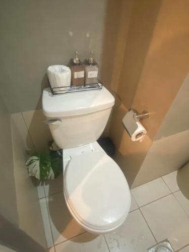 a white toilet in a bathroom with some toilet paper at Isaiah CityScape in Manila