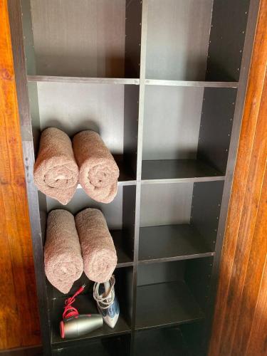 a shelf with three rolled up towels in a closet at Merahi House Cabañas I in Hanga Roa