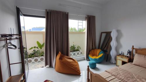 a bedroom with a bed and a large window at Mango Homestay Hà Tiên in Hà Tiên