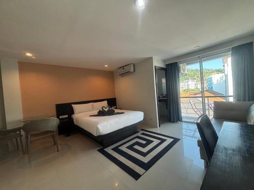 a hotel room with a bed and a table and chairs at Patong gray house in Patong Beach