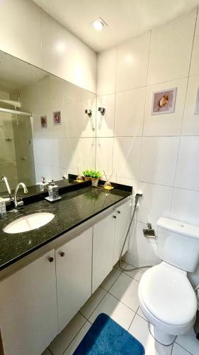 a bathroom with a sink and a toilet and a mirror at Apt 3 quartos com área de lazer in Belém