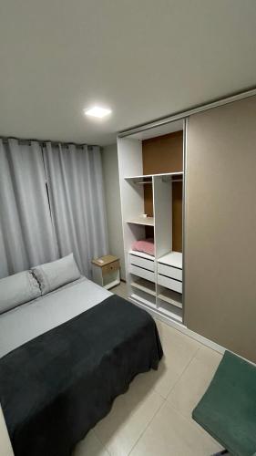 a bedroom with a bed and an open closet at Apt 3 quartos com área de lazer in Belém