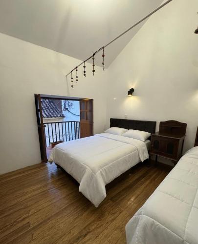 a bedroom with two beds and a window at Antuquita's House in Cusco