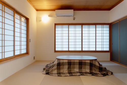 a room with windows and a table in it at まちやど半歩 in Shimo-suwa