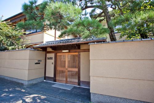 a building with a wooden door and a fence at Shiki Resort Kyoto Kamogawaso in Kyoto