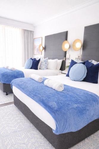 two beds in a room with blue and white at Oceans 11 in Gold Coast