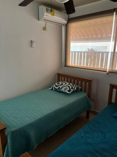 a bedroom with a green bed and a window at Beach House in Coronado in Nueva Gorgona