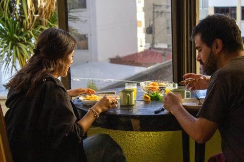 a man and a woman sitting at a table eating food at Casa Rumi - Guesthouse in La Paz