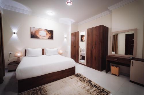 a bedroom with a large white bed and a dresser at Star Luka Private Hotel Room 2 in Luxor