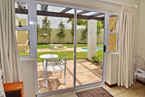 a sliding glass door with a patio with a table at The Gables Hermanus in Hermanus