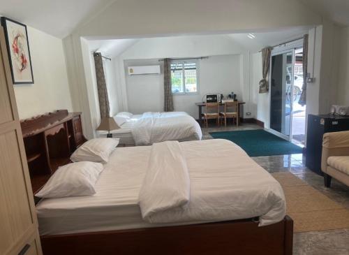 a bedroom with two beds and a living room at AJ Pizza and Steakhouse in Ban Khai Nun