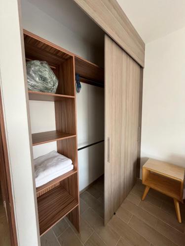 a walk in closet with wooden cabinets and a table at Gran departamento con alberca, terraza y vista a lago en Lago Luna - 5 minutos de Chante Spa in Chantepec