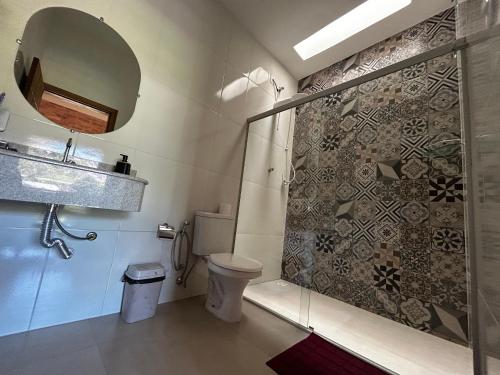 a bathroom with a shower and a toilet at Pousada Acordes do Lago in Cunha