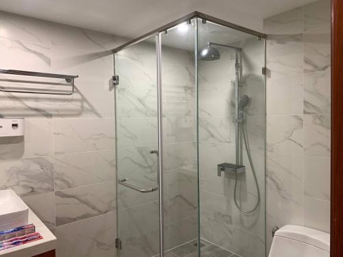 a shower with a glass door in a bathroom at Modern Condo in Phnom Penh ByDN in Phnom Penh