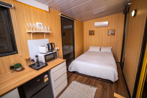 a small room with a bed and a microwave at Gunyah by Tiny Away in Mount McDonald