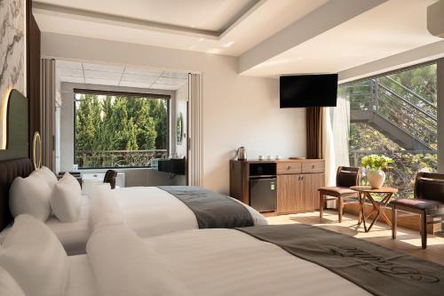a hotel room with a large bed and a balcony at Khách sạn Brume Đà Lạt in Da Lat