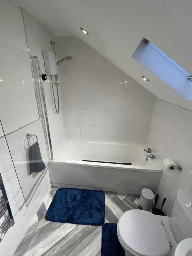 a white bathroom with a tub and a toilet at Stylish 2BR Duplex - Central & Spacious in Sunderland