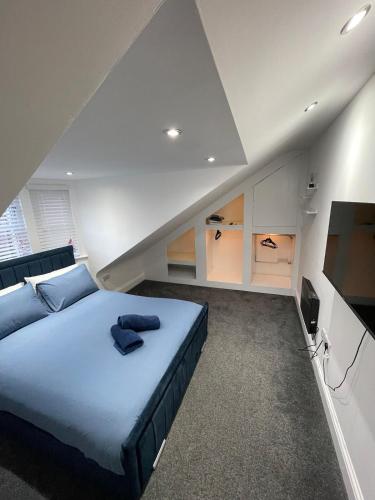 a bedroom with a large blue bed and a flat screen tv at Stylish 2BR Duplex - Central & Spacious in Sunderland