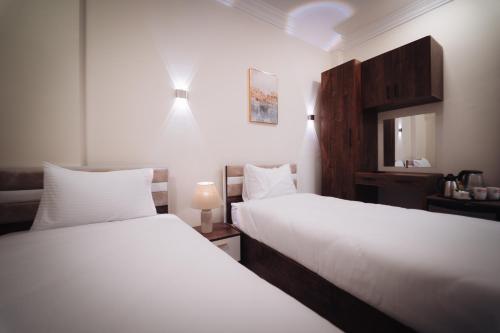 a bedroom with two beds and a mirror at star Luka Luxury in Jazīrat al ‘Awwāmīyah
