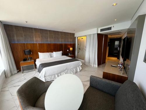 a hotel room with a bed and two chairs at Hotel Nacional in Rio de Janeiro