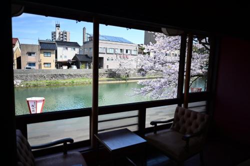 a window with a view of a tree and a river at Japanese Machiya kanazawa private villa Asanogawa in Kanazawa