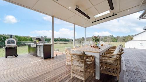 a patio with a table and chairs and a grill at Silos in East Kangaloon