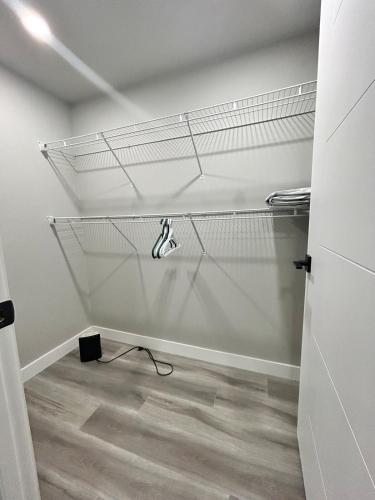 a walk in closet with a wire rack on the wall at Spacious and Stylish Private Basement Suite - 1 bed and 1 rec room in Winnipeg